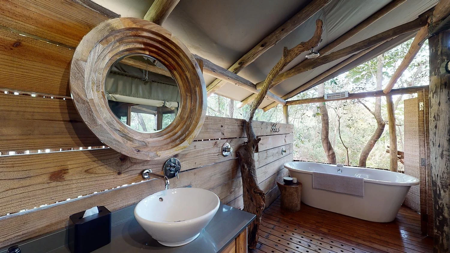 An open bathroom with a bath among the trees